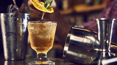 bartender dropping garnish in a drink