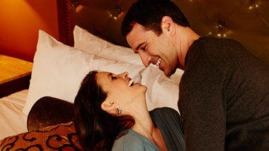 couple joking on River City Casino hotel bed