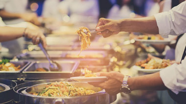 people getting food off of event buffet